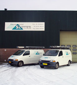 Het pand en de busjes van Sluyer in de sneeuw